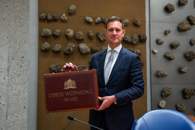 The Minister of Finance, Eelco Heinen, is holding a case on which is written 'Third Wednesday in May', in Dutch.