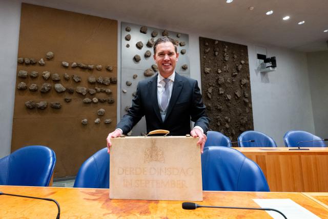Minister Eelco Heinen with a case that says 'Third Tuesday in September', in Dutch