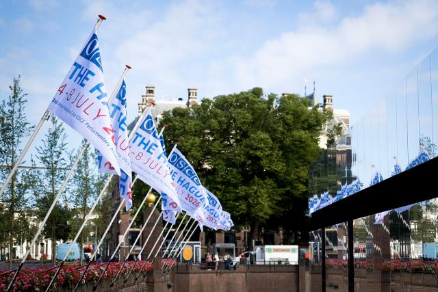 Flags with the logo of the Annual Session of the OSCE PA in The Hague.